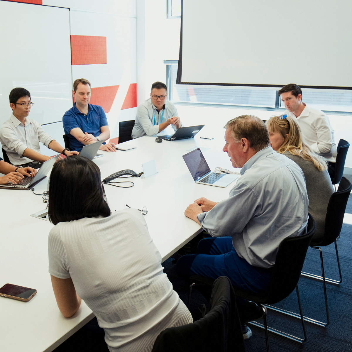 workers around a meeting table in office